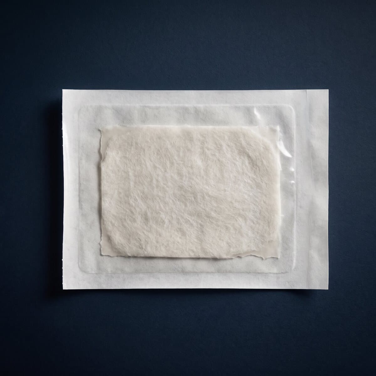 An acellular dermal matrix sheet sealed in a peel pouch